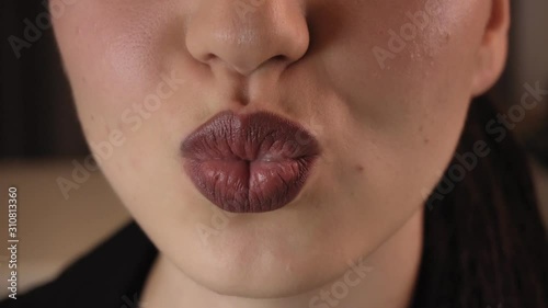 Lips of a young woman close-up. Bright burgundy lips.