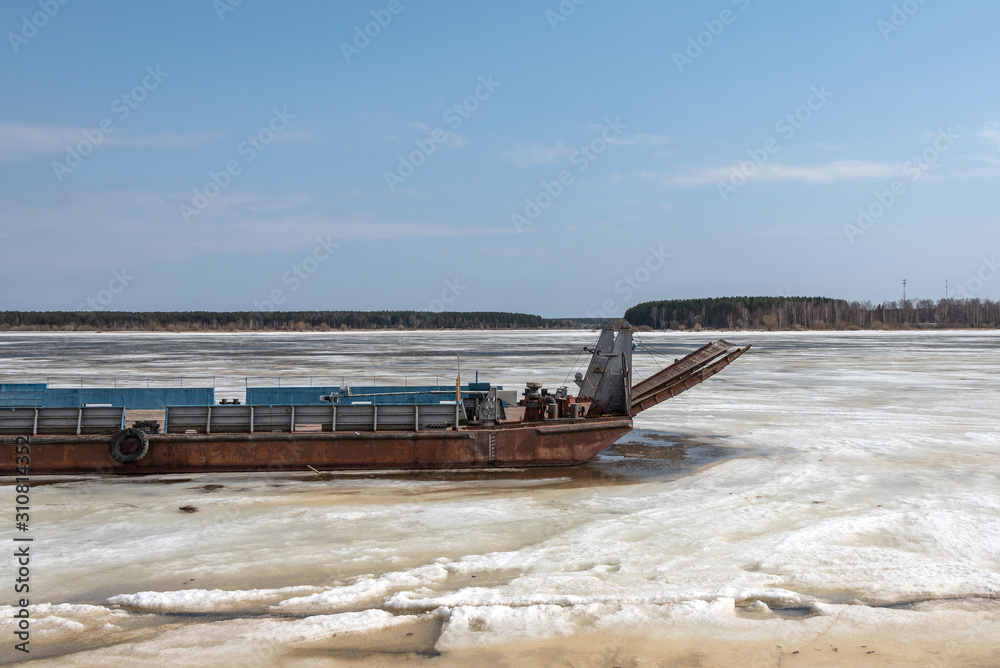 Old river barge on a frozen river