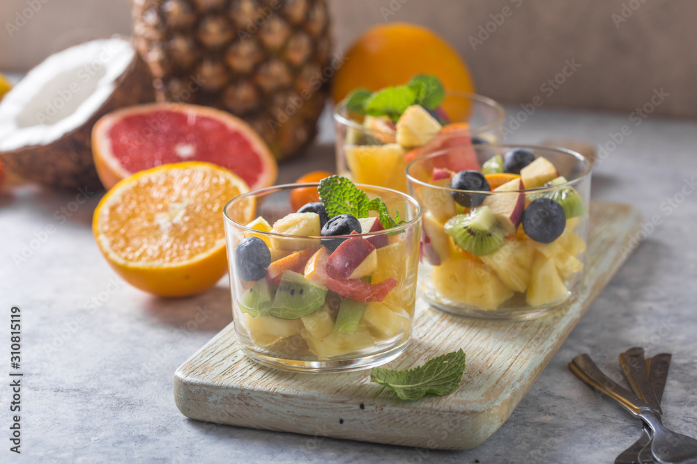 Fruit salad in glasses, fresh summer foods , healthy organic orange kiwi blueberries pineapple coconut. top view Fruit salad in glasses, fresh summer foods , healthy organic orange kiwi blueberries pineapple coconut. top view