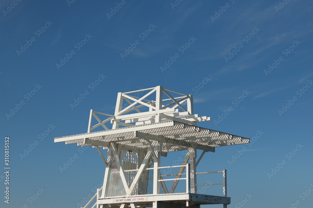 tall white timber public diving stand set against a summer hot blue sky by an ocean side swimming pool, Coastal Victoria, Australia tall white timber public diving stand set against a summer hot blue sky by an ocean side swimming pool, Coastal Victoria, Australia