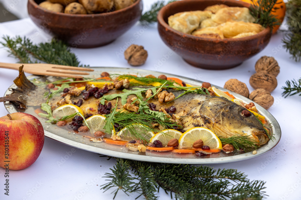 carp with lemon, walnuts and raisins on the plate