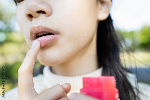 фотографія Asian child girl maintains her lips, beauty and protection, chapped,dry mouth th