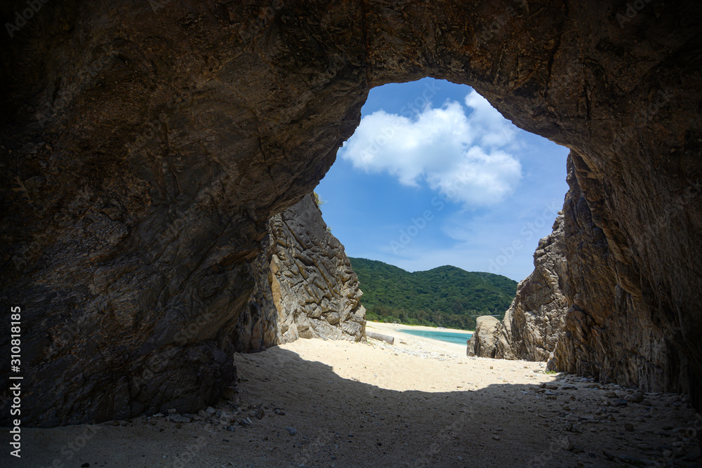 Rock tunnel entrance to Aharen Beach on the tropical island of Tokashiki in Okinawa, Japan