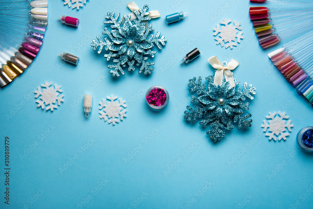 Fototapeta premium Top view of manicure and pedicure equipment on blue christmas background