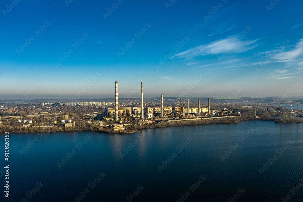 Aerial view of the thermoelectric power station in the City. Industrial zone. Atmosphere, environment. Air pollution.