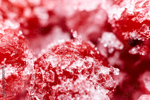Abstract red winter background. Frozen red currants close-up. Blurred. Macro photo.