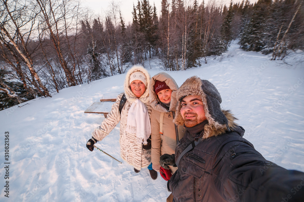 Happy family takes a selfie in the winter forest.