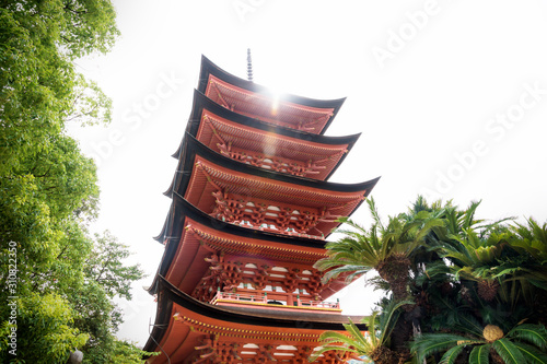 Toyokuni shrine five-story pagoda low angle with sun beam, Miyajima, Japan photo