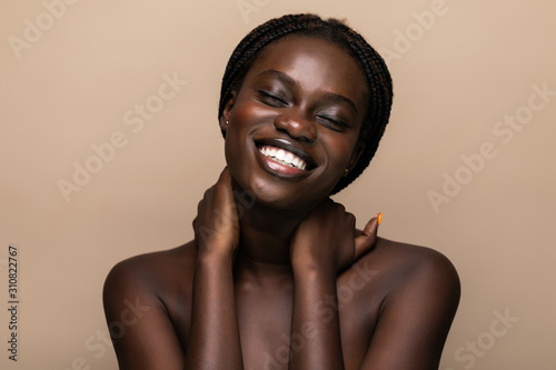 Beautiful African woman healthy and pure skin isolated on beige background