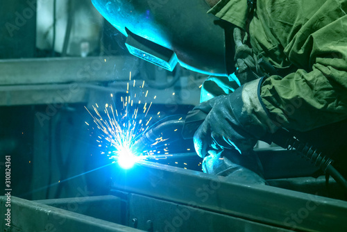 The welder performs welding work with semi-automatic arc welding. Welding stainless steel pipes. Welding MIG.