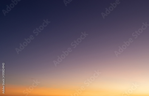 Heaven at early morning with copy space. Smooth orange blue gradient of dawn sky.Sunset, sunrise backdrop.Predawn clear sky with orange horizon and blue atmosphere.  Background of beginning of day. © AungMyo