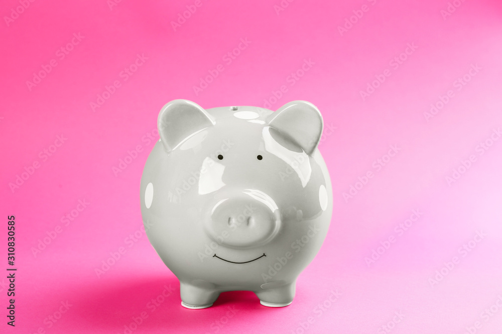 Cute grey piggy bank on pink background
