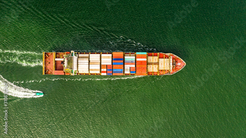 Aerial veaw a Large container ship is leaving the port full loaded with containers and cargo.
