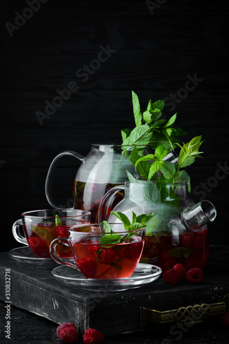 Raspberry and mint tea. Hot winter drinks. On a black background. Top view.