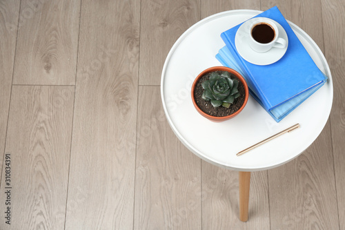 Beautiful Echeveria plant, books and cup of coffee on white table at home, above view. Space for text photo