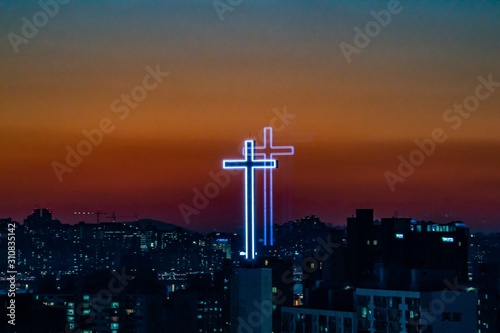 Church Cross with sunset background, viewed through the window. The image of church cross was doubled, which is an artifact but looks interesting. It was aken in Gangnam, Seoul, South Korea.