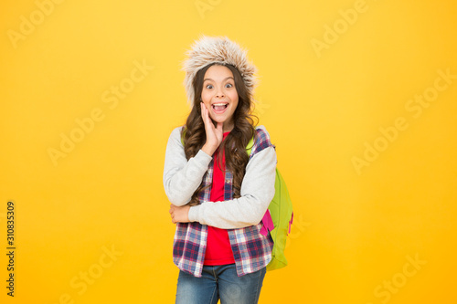 winter school time and holidays. winter courses education. schoolgirl backpack yellow background. course selection period. carefree child pupil. small girl earflap hat. entertainment and activities