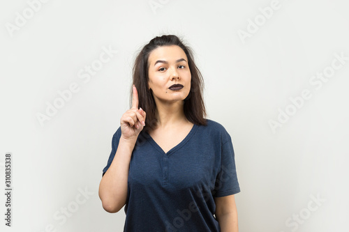 Image of excited young lady with glasses. Looking camera have an idea. Stands on a white background. © Mountains Hunter