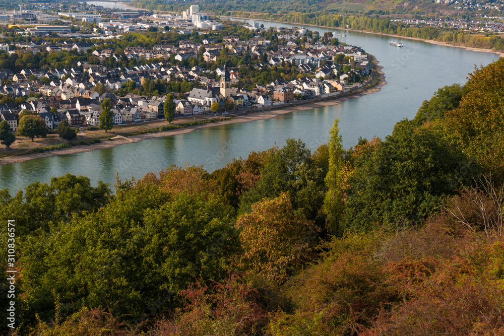 Lovely aerial view of the Rhine river, the city Koblenz at the riverbank and the colourful trees along the hill viewed from the wooden viewing platform near the Ehrenbreitstein Fortress on a nice day.