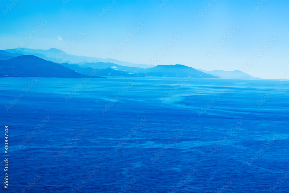 Blue sea and mountains on the horizon. Monochrome landscape. Aerial view.