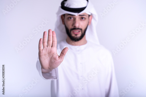 Arab man shoing stop and warning sign isolated on white background.