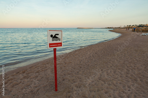 No swimming area sign on the sea beach. Crossed out floating person. © Mountains Hunter