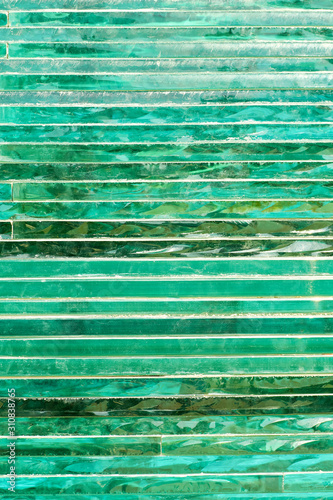 Glass background with stripe pattern in hue of green color.
