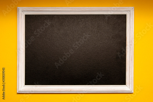 White photo frame with a black middle on a yellow background. Space for text, copy space.