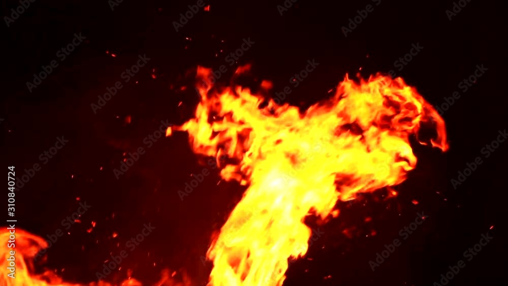 Fire flames with flying sparks on a black background. Firestorm texture. Bokeh lights on black background, shot of flying fire sparks in the air. Burning bonfire over dark night background. 4K UHD