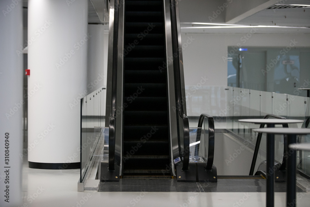 Obraz premium Escalator in Community Mall, Shopping Center. Moving up staircase. electric escalator. Close up to escalators. Close up floor platform. yellow bands. metal line steel. yellow gray steel line.