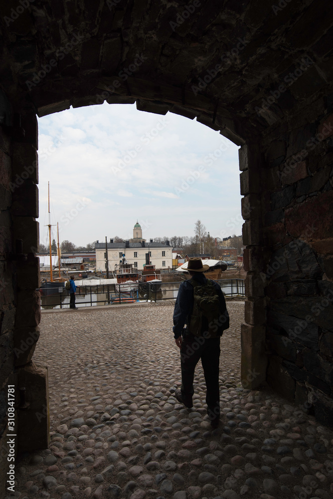 Early spring on Suomenlinna island with person in archway
