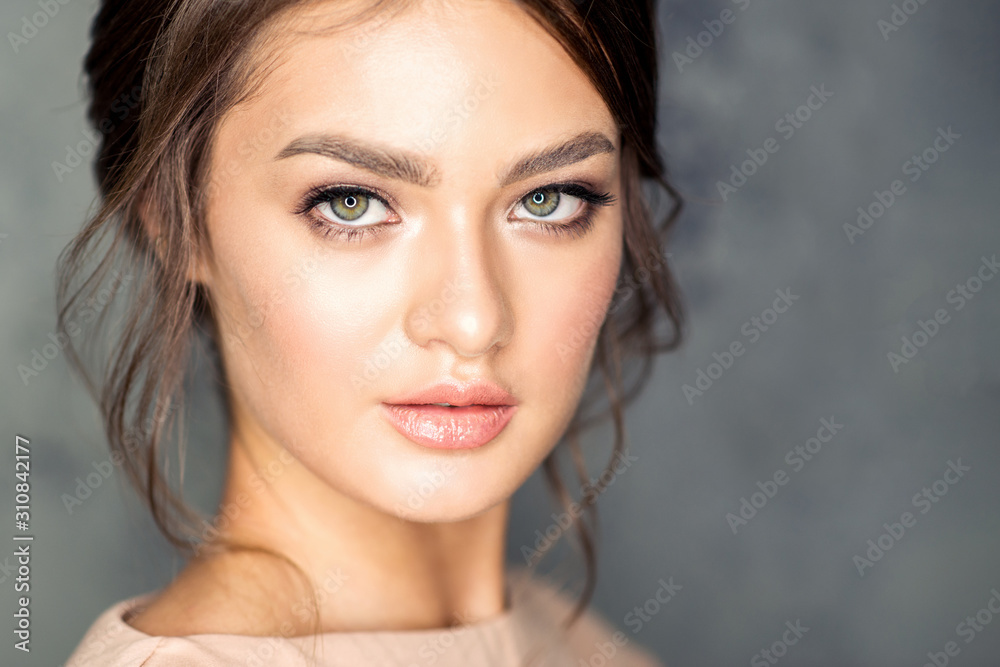 Face portrait of beautiful caucasian young woman with perfect skin and make-up on gray background. Face portrait of beautiful caucasian young woman with perfect skin and make-up on gray background.