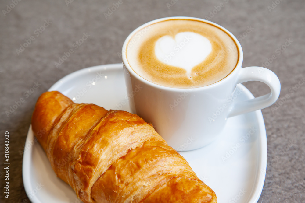 Latte art hot coffee with fresh baked butter croissant Latte art hot coffee with fresh baked butter croissant