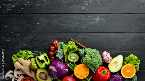 Fresh vegetables on a black background. Vegetarian food. Top view. Free space for your text.