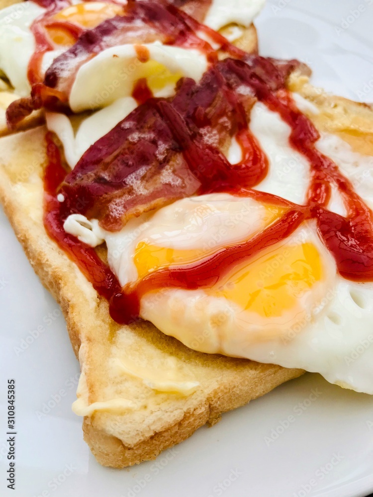 Fried egg and bacon breakfast sandwich with tomato ketchup Fried egg and bacon breakfast sandwich with tomato ketchup