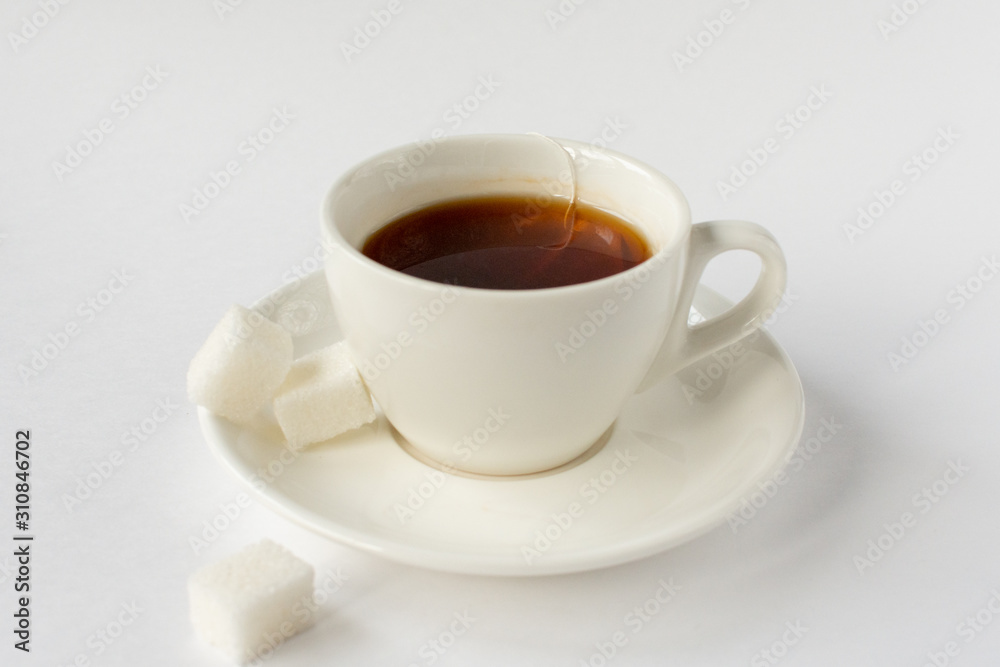 White mug with tea and sugar on a white background.