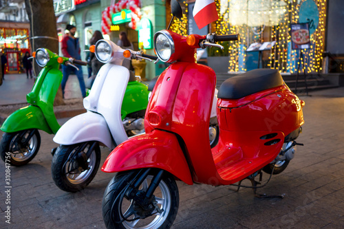 Retro vintage scooters stand near an Italian restaurant. Modern personal transport.