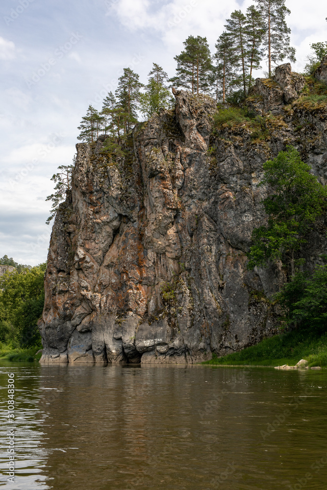 rocky riverbank. Steep high cliffs and the river