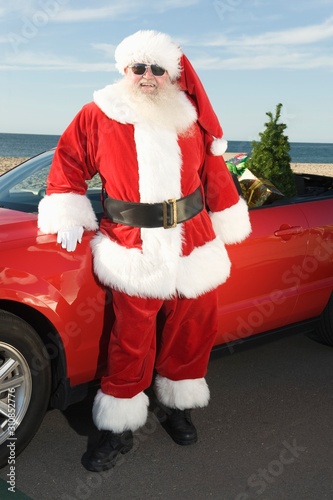 Man In Santa Claus Outfit Standing By The Car © moodboard