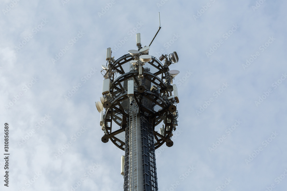 GAUTING, BAVARIA / GERMANY - Dec 11, 2019: Close-up (isolated) of top of a telecommunicatons tower / mast (Mobilfunkmast). Blue sky background. Transmitting signals, e. g. for 5G or LTE networks. GAUTING, BAVARIA / GERMANY - Dec 11, 2019: Close-up (isolated) of top of a telecommunicatons tower / mast (Mobilfunkmast). Blue sky background. Transmitting signals, e. g. for 5G or LTE networks.