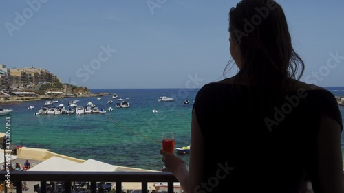 Beautiful woman enjoying drink on a terrace at resort
