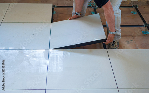 Worker install of raised floor in equipment room to spare space underground