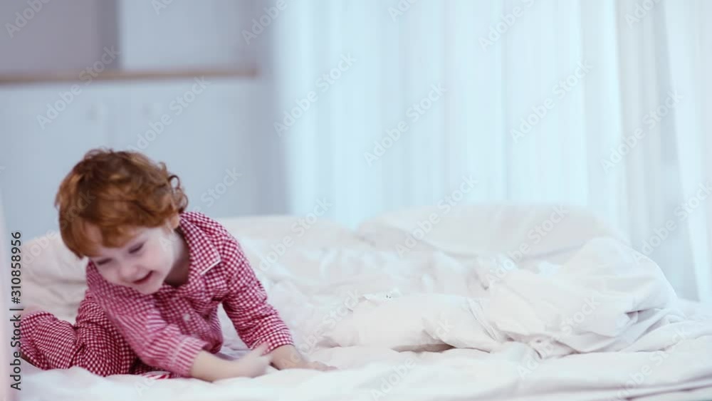 cute happy boy, kid in pajamas jumping on the bed cute happy boy, kid in pajamas jumping on the bed