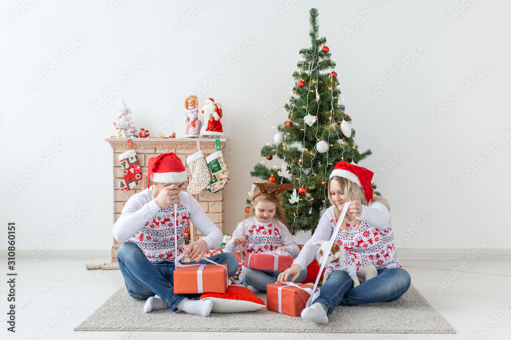 Holidays and presents concept - Portrait of a happy family opening gifts at Christmas time Holidays and presents concept - Portrait of a happy family opening gifts at Christmas time