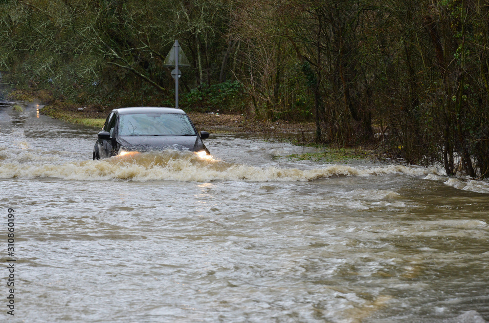 Naklejka premium Horley,Surrey/United Kingdom- December 29 2019: The river Mole has flooded its banks, cars are trying to drive through the flood waters