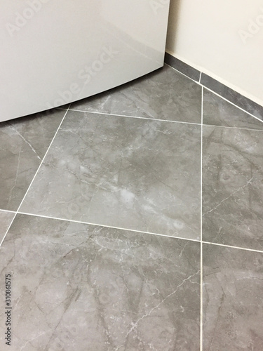 Domestic kitchen clean tiled floor with refrigerator