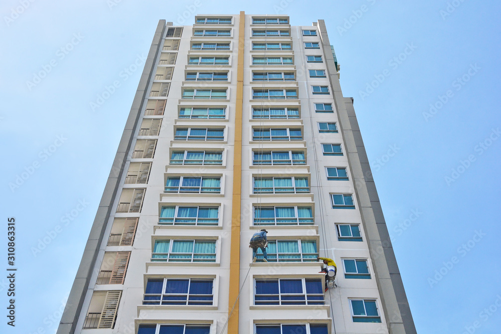 Skycraper windows cleaner office windows with ropes of high skyscraper,