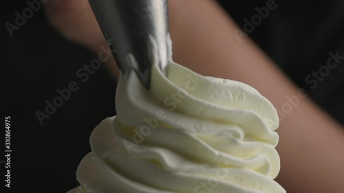 Hand piping whip cream with a piping bag.