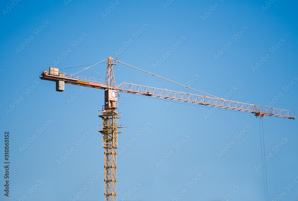 yellow construction crane on a background of blue sky yellow construction crane on a background of blue sky