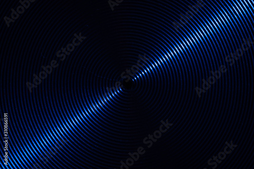 A close up macro photo of circular brushed steel metal texture with a diagonal blue line